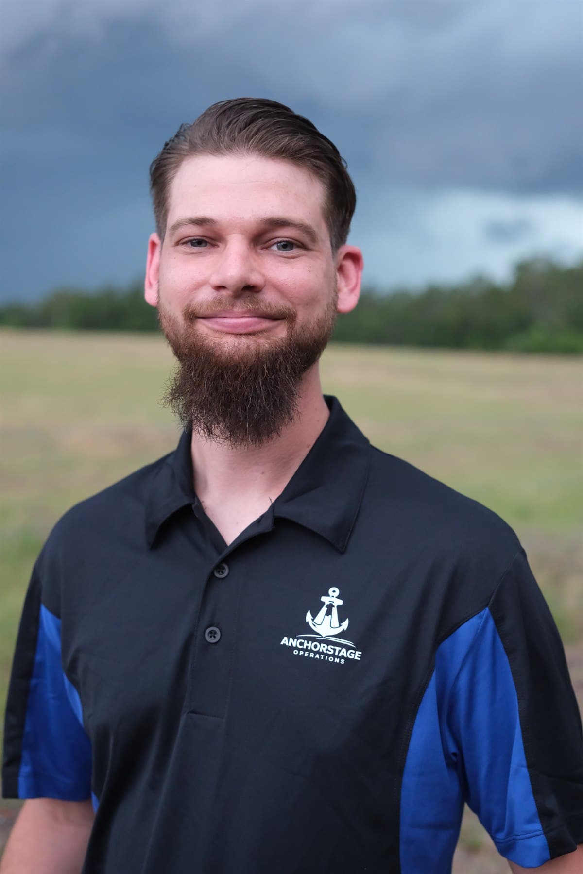 Cody Williams, Founder and Live Event Operator of AnchorStage Operations, outdoors in an ASO-branded shirt.